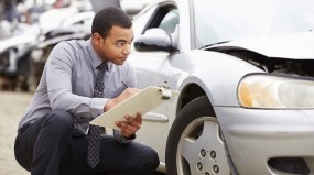 Loss Adjuster Inspecting Car Involved In Accident